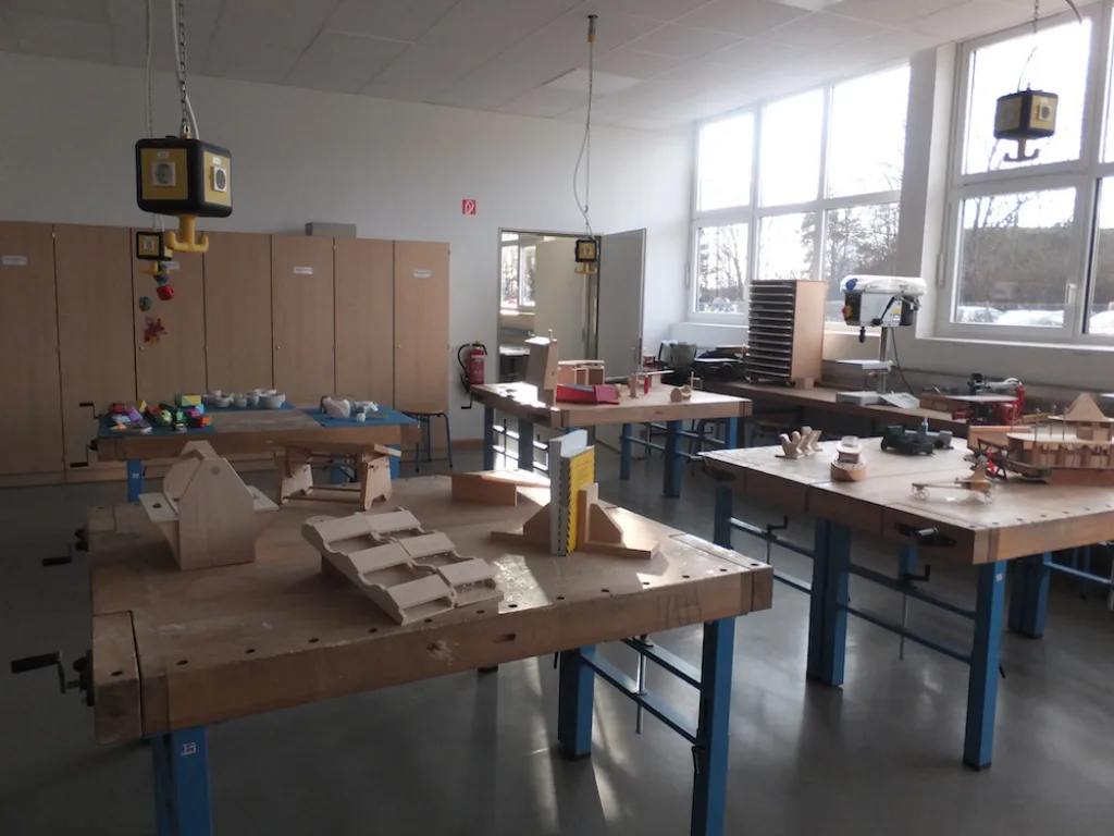 Werkraum mit Werkbänken und gebauten Modellen.